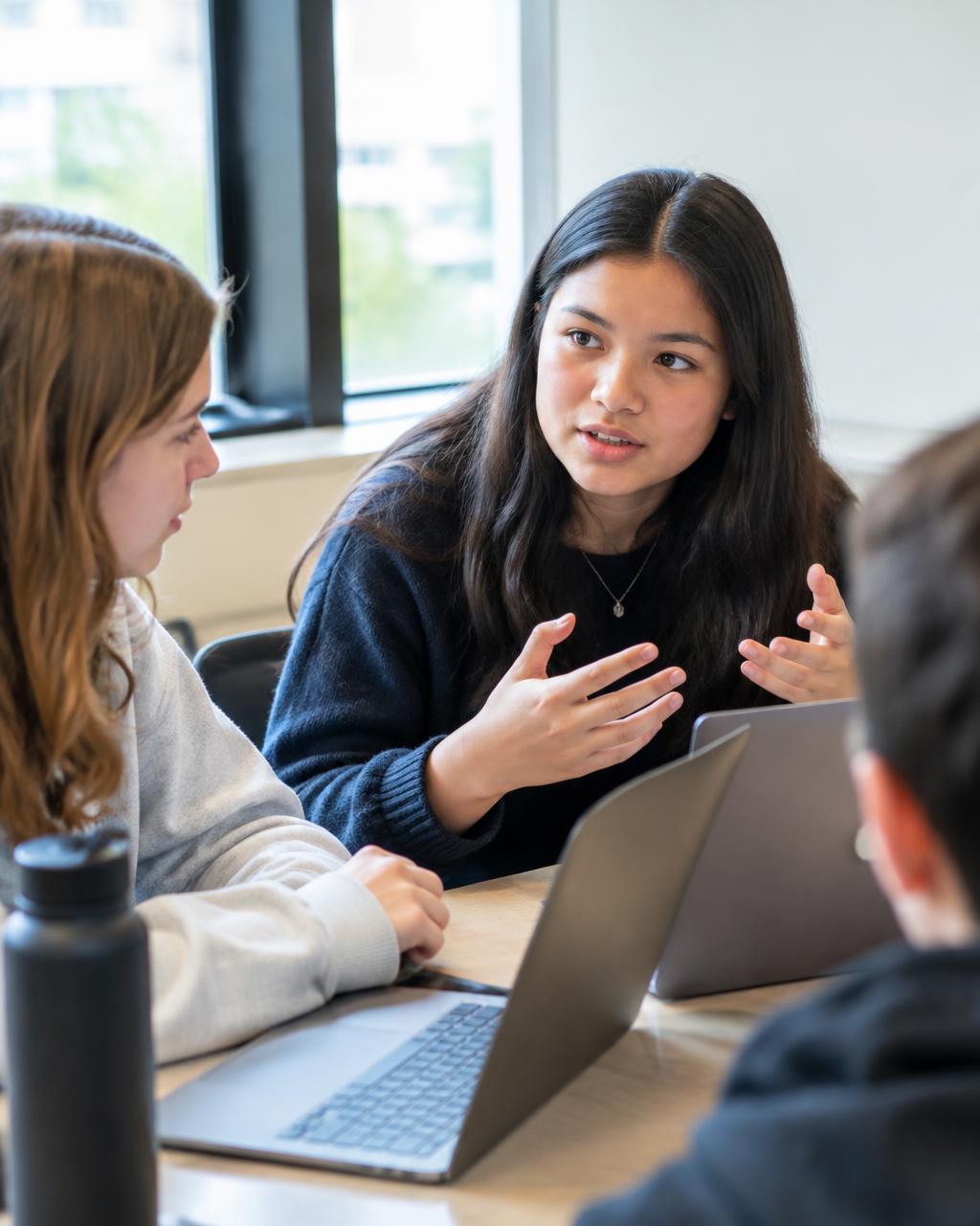 a student explaining her idea to her team