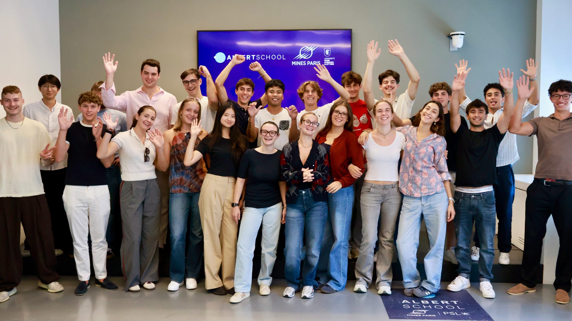 A large group of students waving after a workshop
