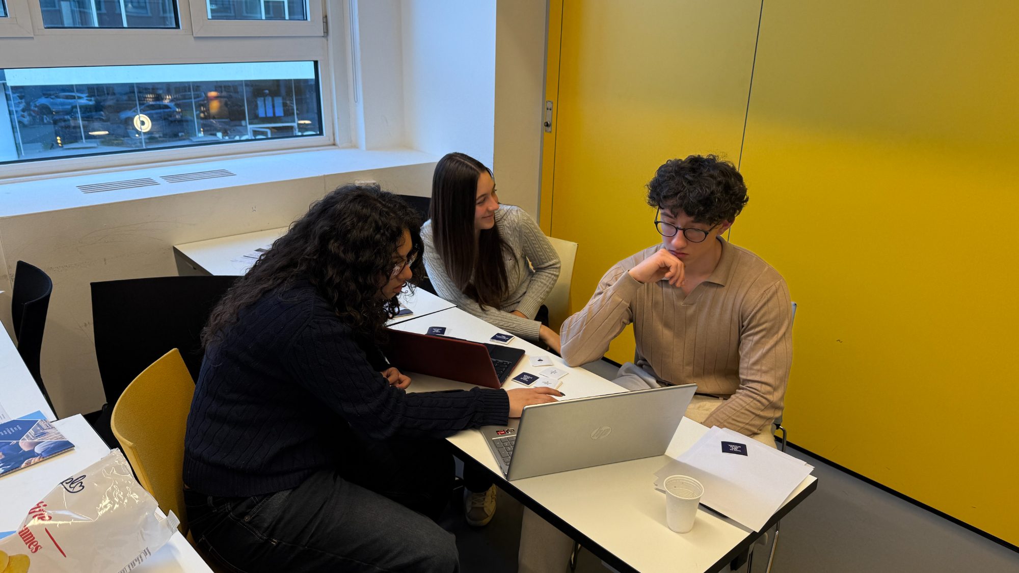 Three students working together on a laptop
