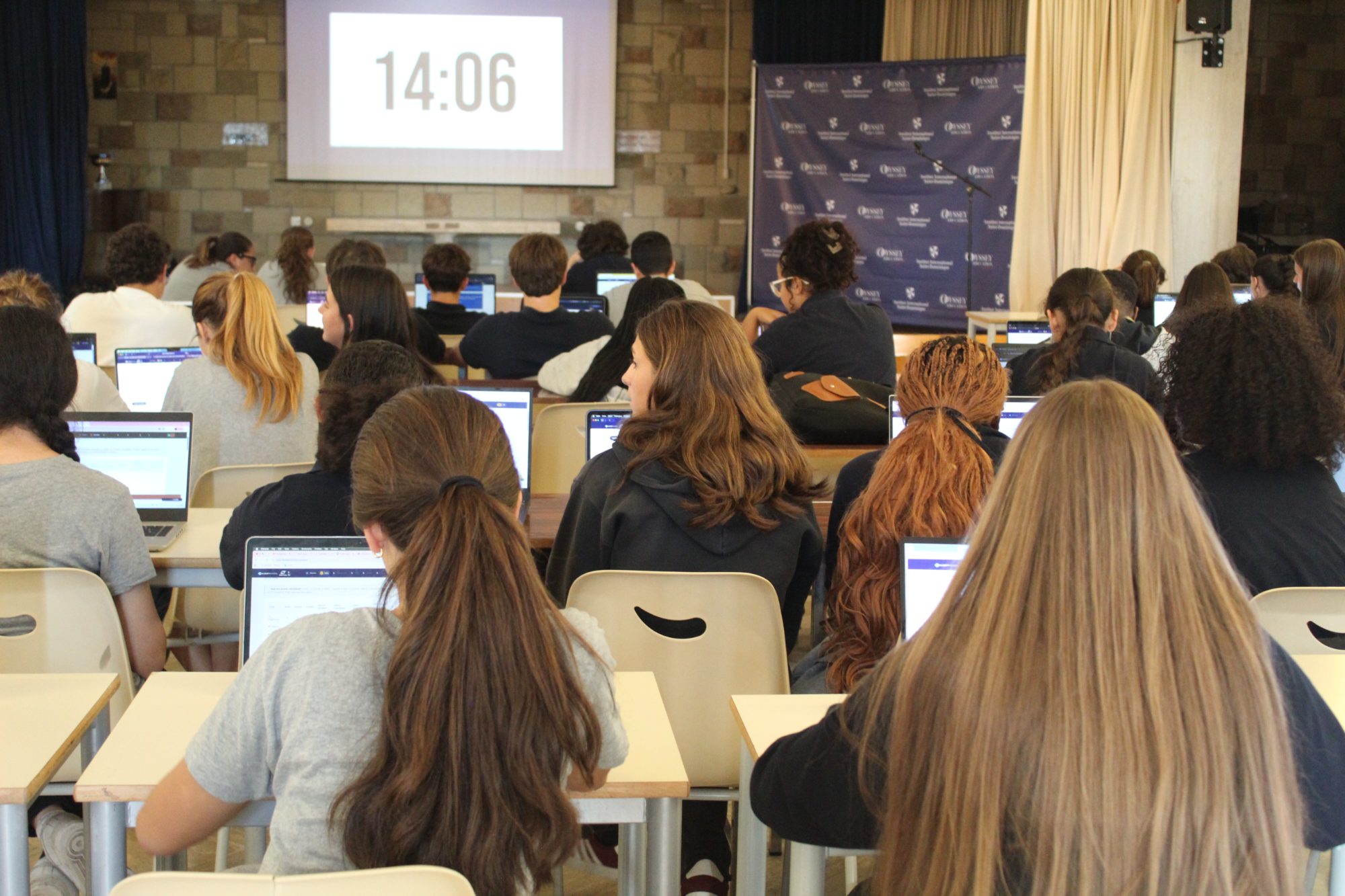 A full hall of high school students working on laptops during an AI Discovery Day, timer on the screen